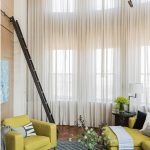 Scala a pioli in soggiorno con soffitto alto