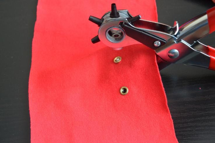 Installazione degli occhielli sul tessuto rosso