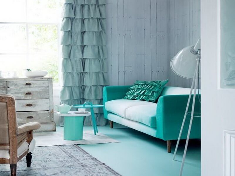 Divano turchese accanto a una tenda color menta