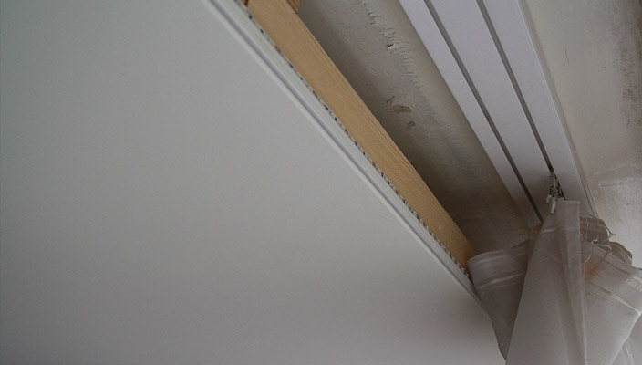 Bastone per tende in plastica nella nicchia del soffitto