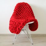 Ampia coperta lavorata a maglia in lana di un intenso colore rosso
