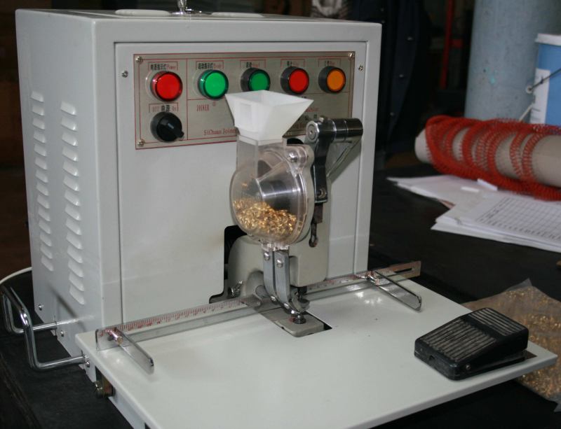 Unità di alimentazione degli occhielli su una pressa elettrica