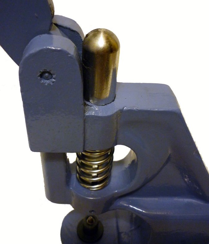 Molla di ritorno sull'albero di una pressa manuale per occhielli