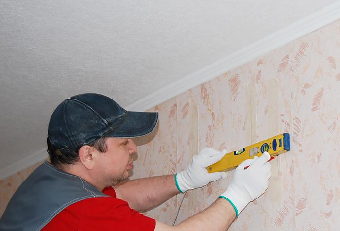 Segnare il muro per la cornice utilizzando una livella a bolla