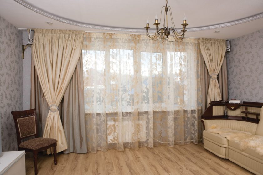 Decorare una finestra in un ingresso di una casa a pannelli con una combinazione di tende diverse