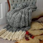 Plaid grigio e bianco con grandi coste lavorate a maglia