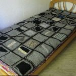 Coperta grigia realizzata con quadrati lavorati all'uncinetto
