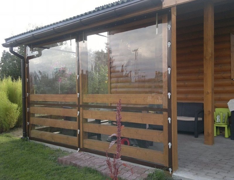 Veranda in legno di una casa privata con tende in PVC