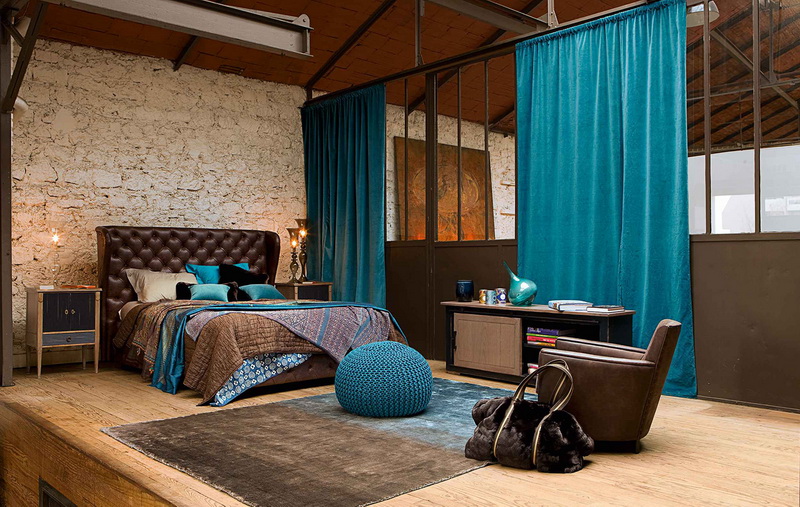 Ampia camera da letto in stile loft con tende dritte color turchese