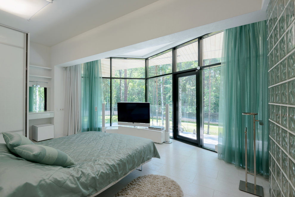 Ampio interno della camera da letto con tende turchesi