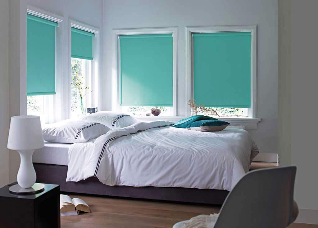 Tende a rullo turchesi alle finestre della camera da letto