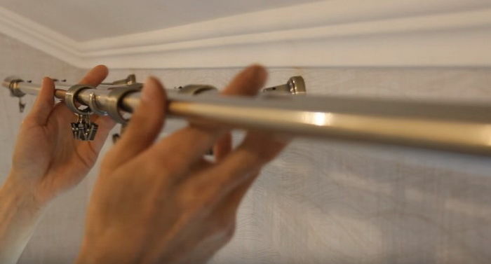 Appendere il tubo dell'asta della tenda alle staffe