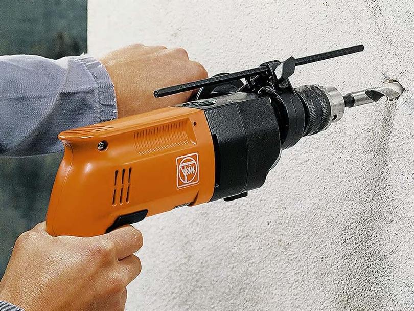 Foratura di un muro di cemento durante l'installazione di un'asta per tende