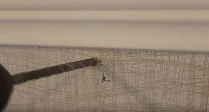 Forare una parete durante l'installazione di un'asta per tende