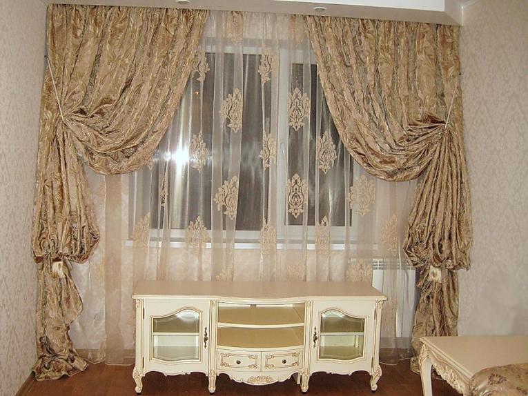 Decorare una finestra in un ingresso di un appartamento in città con tulle e monogrammi