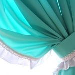 Decorare le tende color menta con un nastro bianco
