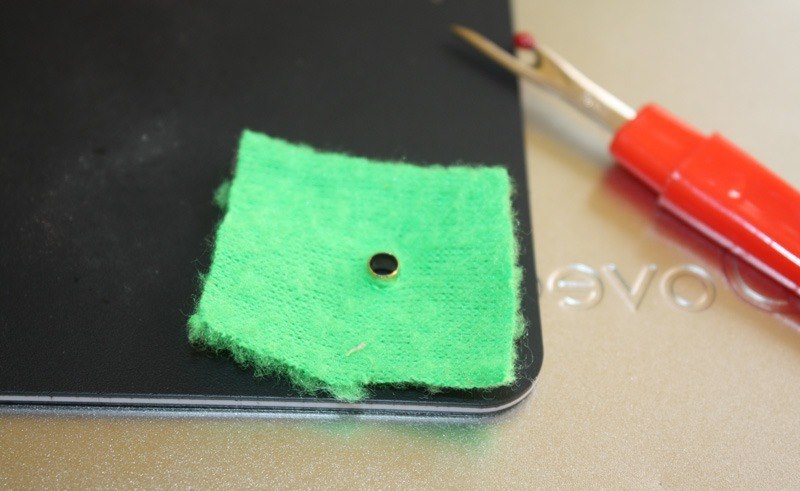 Un esempio di installazione di un occhiello su un pezzo di tessuto verde