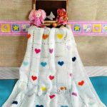 Coperta bianca con cuori multicolori, lavorata a maglia