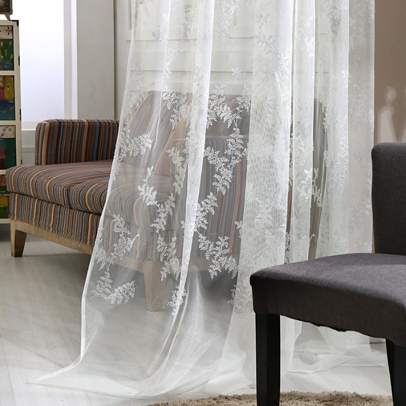 Tessuto in tulle bianco con motivo floreale
