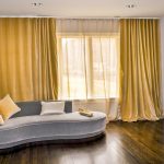 Decorare una grande finestra nel soggiorno di un appartamento in città