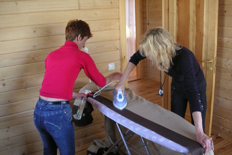 Due casalinghe che stendono una lunga tenda