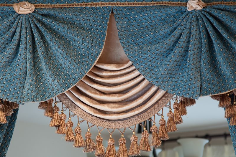 Foto di un lambrequin a forma di conchiglia con nappe nella parte inferiore