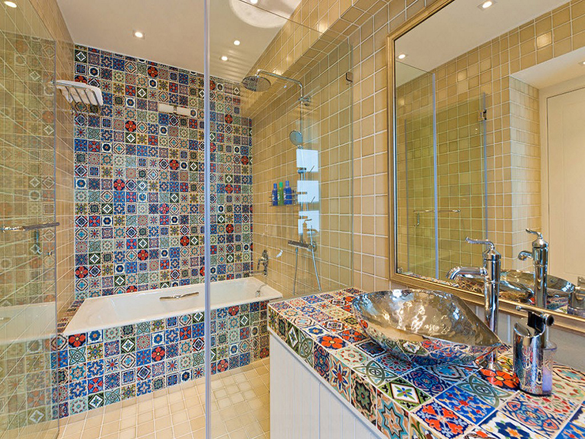 Parete divisoria in vetro nel bagno con piastrelle a mosaico