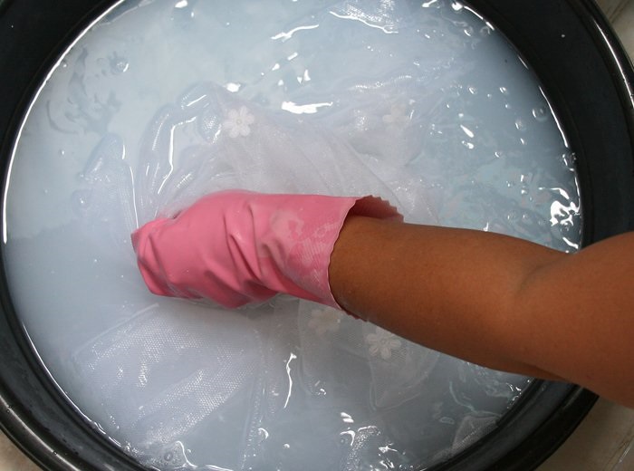 Inamidare il tulle bianco in una bacinella di plastica