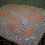 Delicata coperta quadrata decorata con fiori lavorati a maglia
