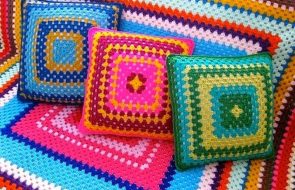 Coperta e cuscini per il divano realizzati con fili multicolori a forma di quadrato