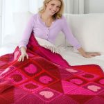 Coperta all'uncinetto realizzata con quadrati rosa e rossi con cuori