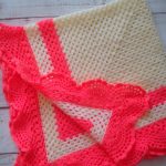 Coperta all'uncinetto color latte con decorazione corallo