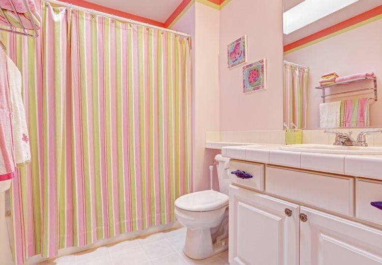 Tenda a righe in un bagno con pareti rosa