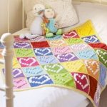 Copertina per neonati multicolore con cuori realizzati con pigne
