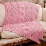 Coperta lavorata a maglia rosa con strisce e cuori al centro