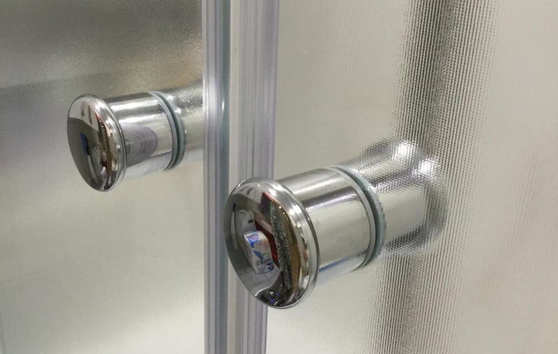 Maniglie cromate sulle porte in vetro della parete scorrevole