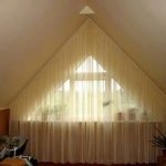 Tende per tutta la parete con finestra triangolare