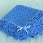 Coperta lavorata a maglia blu con bordo traforato