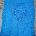 plaid lavorato a maglia per bambini con cappello blu