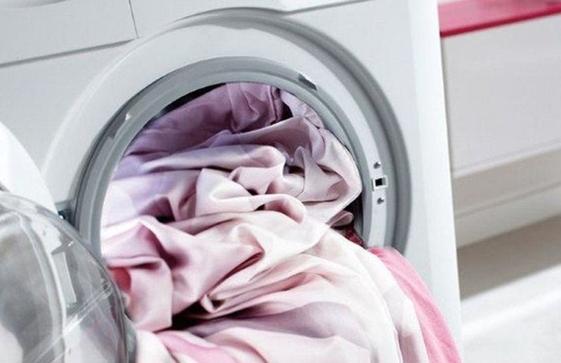 Caricamento delle tende nel cestello di una lavatrice automatica
