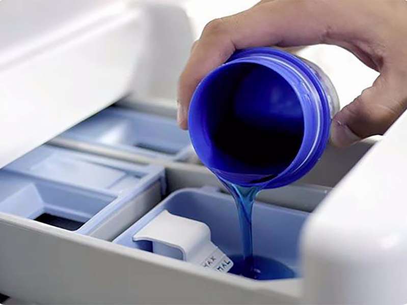 Versare il gel liquido per il lavaggio delle tende nel vano della macchina