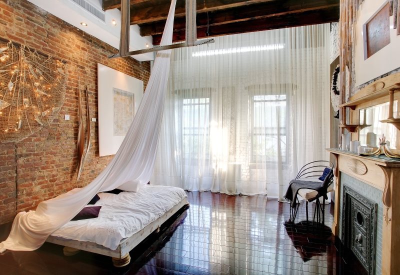 Lunghe tende di tulle bianco in una camera da letto in stile misto