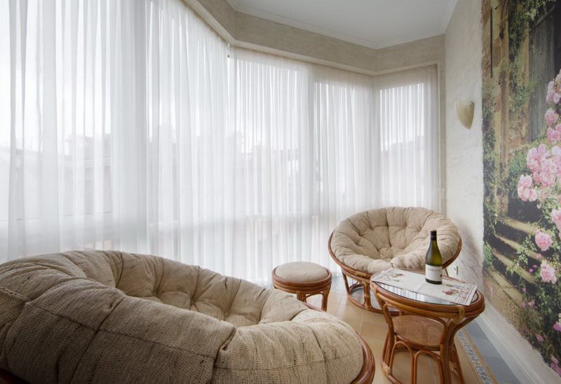 Sedie comode in una stanza con tulle bianco