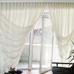 Tende delicate su una finestra con porta sul giardino