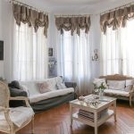 Tende traslucide sulle finestre alte della sala