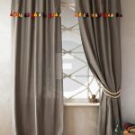 Tende grigie su anelli con nappe multicolori