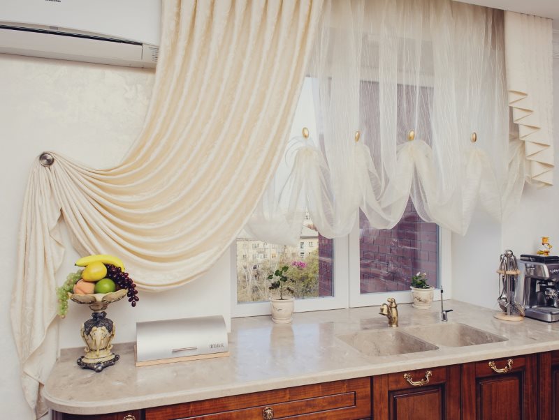 Tulle con volant sulla finestra della cucina con tenda beige