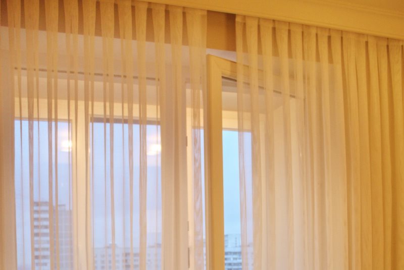 Decorare una finestra del soggiorno con tulle di organza plissettato