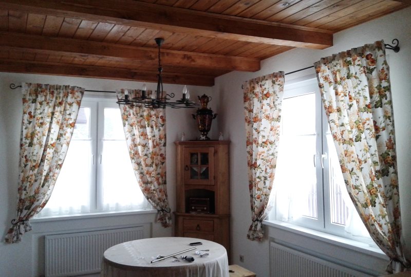 Tende leggere alle finestre della sala con soffitto in legno