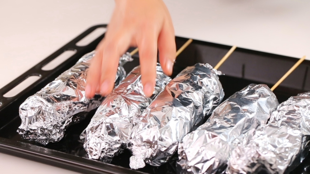 cibo in un foglio di alluminio su una teglia da forno